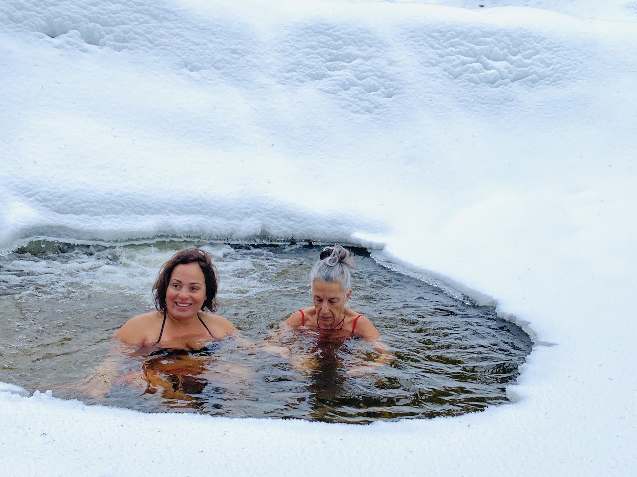 Participant dans un bain de glace en bois au milieu d'une forêt enneigée